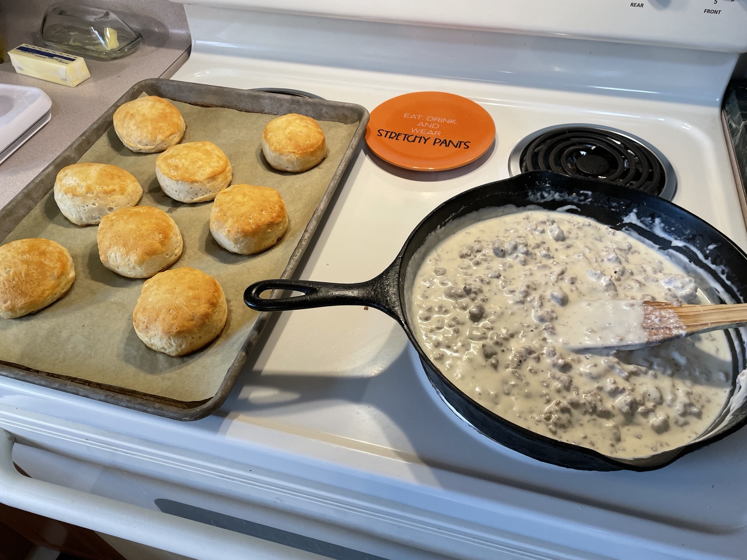 Sausage gravy in cast iron beside warm biscuits